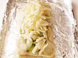 油揚げに刻みねぎをこれでもか！というくらいのせて焼く。チーズが溶けると、接着剤代わりになるのでたくさんのせても大丈夫。
