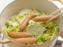 炒めたキャベツとじゃがいもの上にのせ、キャベツの水分とスープで蒸し煮にする