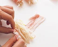 肉の手前にゆでたもやしを横向きに置き、しっかりと巻いて、くずれにくくする。