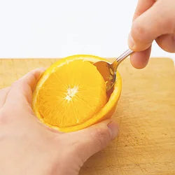 切り込みを入れたあとに、小さめのスプーンを深く入れて芯(しん)の部分を断ち、果肉を取り出す。