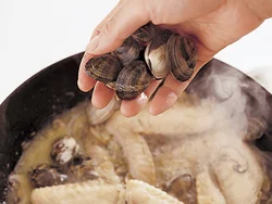 手羽先に火が通ったらあさりを加える。口が開くまで煮て、うまみを出して味をしみこませる