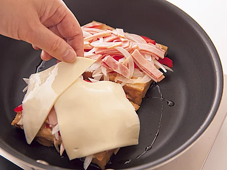 厚揚げの上に具をのせたら、スライスチーズをおおうようにのせ、蒸し焼きにして火を通す