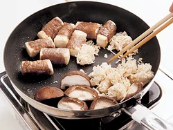 肉に焼き色をつけたところで、しいたけと切り干し大根を炒め、肉のうまみをしみこませる