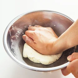 豆腐をくずし、全体が均一に混ざったら、表面がなめらかになるまで手のひらのつけ根でしっかりこねる。耳たぶくらいの弾力が目安。