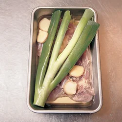 とり肉はたっぷりの酒で蒸すことで、しっとりとジューシーに仕上がる。上にのせた長ねぎの青い部分としょうがには、臭み取りの効果が。