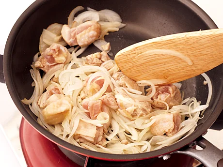 玉ねぎ、とり肉をフライパンで炒める