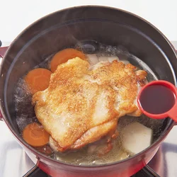 焼いていない部分を下にして、野菜の上にとり肉を置くと肉のうまみが野菜に程よく移る。とり肉の焼いた部分があまり煮汁にひたらないよう、煮汁は少なめ。