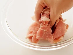 豚肉に片栗粉をまぶし、手でよくもむ。こうしてから炒めると、つるりとした食感に仕上がる。