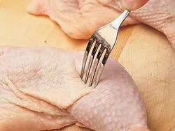 大きく厚みのある骨つきもも肉は、味をしみやすく、火の通りをよくするため、穴をあける。