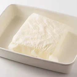 豆腐は、二重にしたペーパータオルでふんわりと包んでバットなどにのせ、水けをペーパータオルに吸わせる。これを2回ほど繰り返すと、程よく水きりできる。