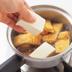 絹ごし豆腐はやわらかくくずれやすいので、鍋に１切れずつ入れていく。重なるとくずれてしまうので、油揚げを端に寄せて、すき間からそっと入れていくのがコツ。