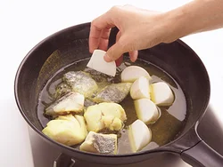 フライパンに煮汁を煮立てたら、火の通りにくいものから、たら、かぶ、かぶの葉の順に入れる。