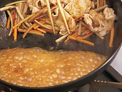 フライパンの端で黄金だれを煮詰めてから肉や野菜にからめると、うまみが逃げない。