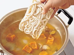 うどんは凍ったまま加え、袋の表示どおりにゆでながら煮込んで、味をしみこませる。