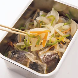 揚げたての熱いうちに漬け汁に漬ける。全面に味をしみこませるために、先に入れて味がしみた野菜をあじの上にのせるようにしておくとよい。