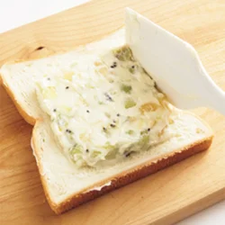 フルーツ入りのクリームチーズをパン全体に広げてから中央に寄せると、縁に薄く残ったクリームが、のり代わりになる。