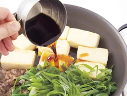 たれは最後に加えて全体にからめる。豆腐は片栗粉をまぶして焼いているので、外側がカリッとし、そこにたれがからむ。