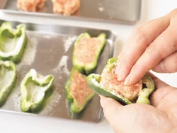 ピーマンの内側に、肉だねがはがれないように片栗粉をふり、肉だねをすき間なく詰める。