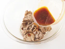 炒めた牛肉をボウルに入れ、味がしみやすいように、肉が熱いうちにマリネ液をかける。