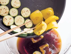 野菜とあじを焼いたら、熱いうちに漬け汁に漬け、味のしみこみをよくする。