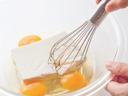 豆腐と卵を混ぜて、ピザの生地に見立てる。泡立て器でよく混ぜるだけでいい。