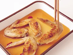 焼き上がったとり手羽先は、熱いうちに漬け汁に漬け込むと、味がよくなじむ。