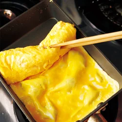 菜箸を焼いた卵にぐっと差し込むと手早く巻ける。箸を刺した穴は、そのあと卵で巻いてしまうので見えない。