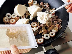 豆腐はスプーンですくって加え入れる。味がよくなじみ、口当たりのやわらかい仕上がりになる。