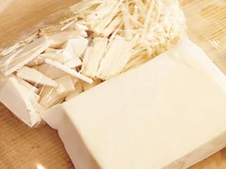 きのこはラップで包み、豆腐はペーパータオルで包んで電子レンジ加熱すると、きのこの加熱と豆腐の水きりが一気にできる。