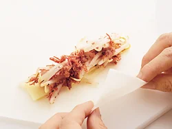 細切りのスライスチーズ２切れを、少し重ねて幅12cmくらいに置き、もやしとコンビーフをのせる。