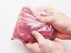 手ごろな価格のステーキ用牛肉は赤身が多く、そのまま焼くとかたくなりがち。油と赤ワインを入れたマリネ液に漬けると、肉が程よく油分を吸収し、赤ワインの色になるので、色よくジューシーに焼き上がる。