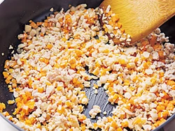 とりひき肉をぽろぽろに炒めてから、にんじんと大豆を加えて混ぜ、とり肉のうまみを野菜に移す。