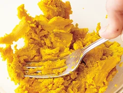 かぼちゃはフォークの背を使ってよく潰して。牛乳、クリームコーンで溶きのばして煮汁に加える。