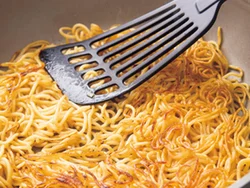 フライパンに麺を広げ、へらで押さえながらこんがり焼きつける。