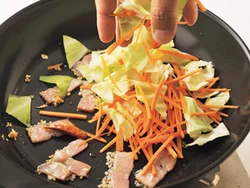 にんにく、とうがらし、ベーコンを炒めて、充分に風味を引き出したところで、野菜を加える。