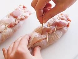 とり肉をくるくると巻いた巻き終わりをようじで留める。巻き終わりに対してようじを斜めに刺すとはずれにくい。