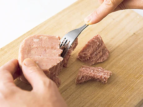 ランチョンミートはフォークで一口大にほぐすと、断面がぎざぎざになって、味のなじみがよくなる。