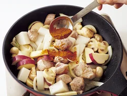豚肉と野菜を炒め、全体に油がまわったところでカレー粉を加えると、油にからんでなじみやすい。