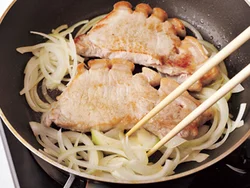 豚肉を焼いたフライパンのあいたところに玉ねぎを入れ、肉から出た脂で炒める。