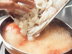 煮立ったスープに、魚介を加える。スープは玉ねぎ、カットトマトを煮て、香りよく仕上げておく。