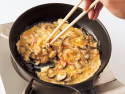 具を加えた卵液は、空気を含ませるように菜箸で大きくかき混ぜ、ふんわり仕上げる。