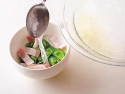 とり肉の蒸し汁をスープの器に注ぐ