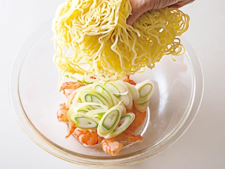とり肉の蒸し汁に具と麺を加えて加熱