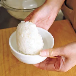 おむすびを作るときは、炊きたてのご飯を使うのがベスト。器を両手で持ち、そっとふって、ご飯をぽんぽんと弾ませると、熱さがやわらぐ。