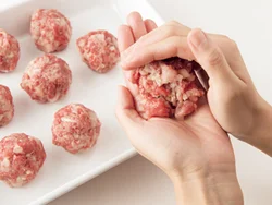 牛肉に玉ねぎ、塩、こしょうを加え、練り混ぜるうちに脂がなじんで、丸めやすくなる。