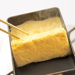 巻くときは卵焼き器を傾けて、焼いた卵を持ち上げ、奥に倒すようにして巻いていくと、楽に素早くできる。
