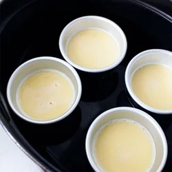 ふたについた水滴がプリン液に落ちると、なめらかな食感にならないので、ふたをふきんなどで包んで防ぐ。