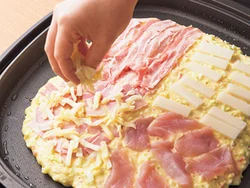 生地を大きく広げたらすぐに、４分割するイメージで４種類の具を並べていく。こんがりと焼き色がついたらへらで切り分けて。
