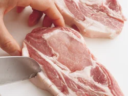 肉は蒸したときに縮んで、ごまペーストが落ちないように、赤身と脂肪の間の筋を、包丁で深めに刺すようにして筋を切る。