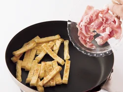 まず油揚げをこんがりと焼き色がつくまで焼いてこうばしい風味をつけてから、豚肉を加える。